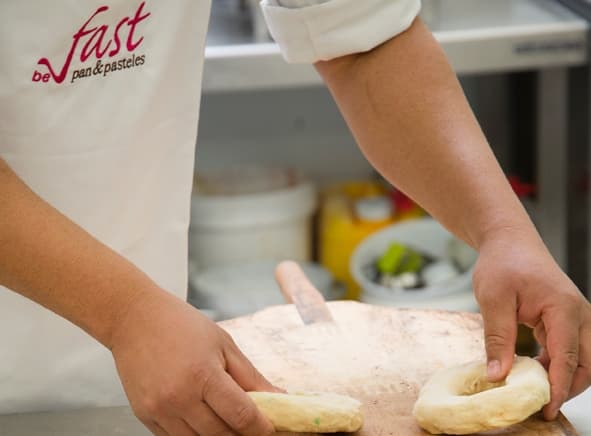 Manos de panadero formando roscas de masa